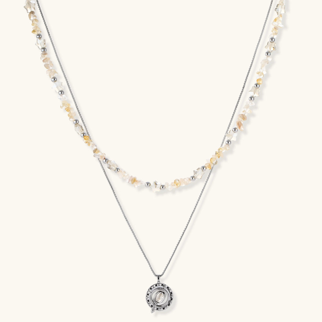 Two-layer necklace with natural stone chips and eco-brass beads, featuring a circular wrapped pendant on cream background.