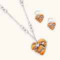 Heart-shaped eco-brass and wood jewelry set with silver wire detailing and crystal accents on cream background.