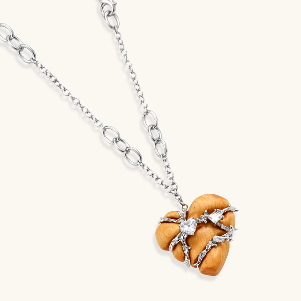 Heart-shaped eco-brass and wood jewelry set with silver wire detailing and crystal accents on cream background.